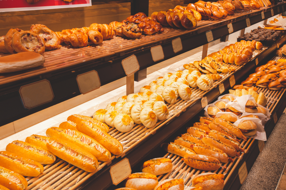 A Japanese bakery display case full of breads and pastries